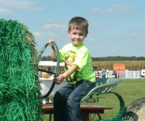Boy driving straw tractor