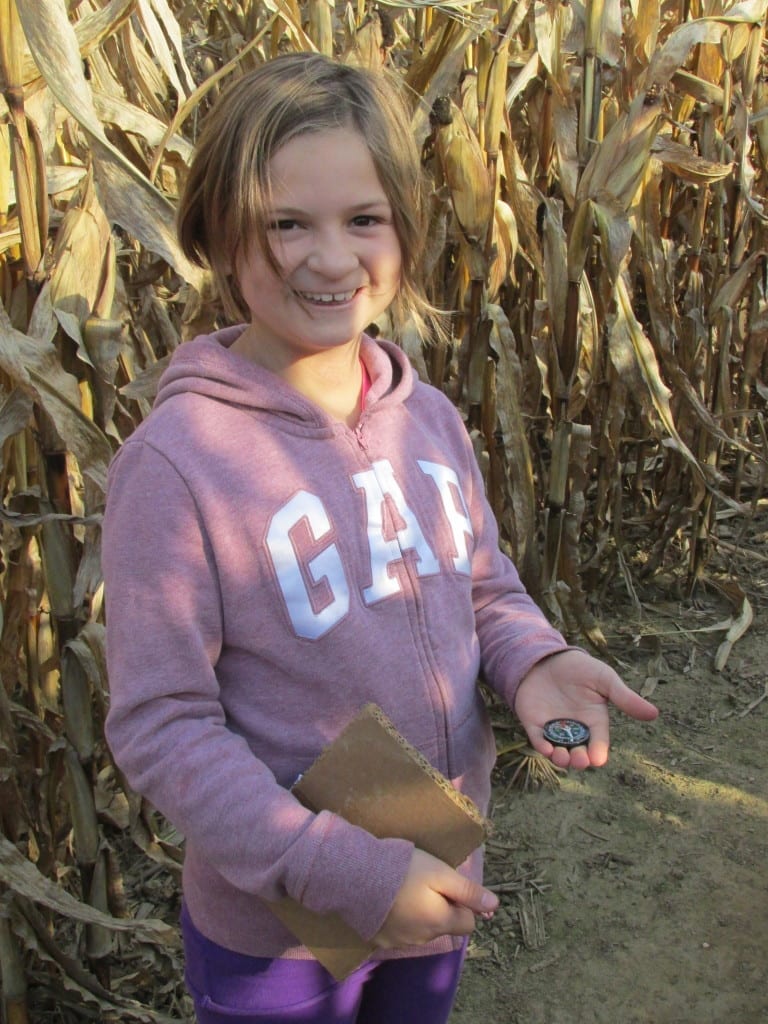 Girl with compass in corn maze